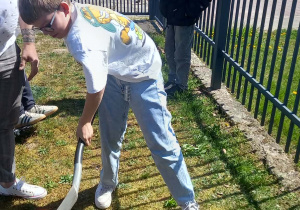 Uczeń wykopuje dołek na zasadzenie drzewka.